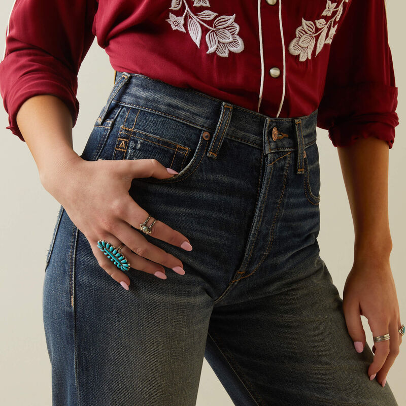 Woman in jeans and red shirt with ring.