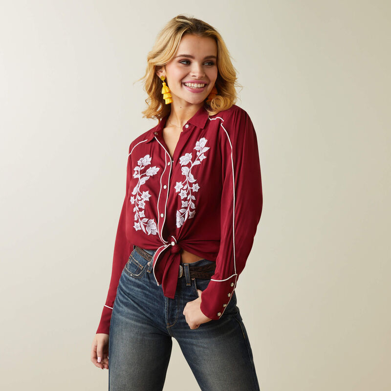 Woman in red floral shirt and jeans.