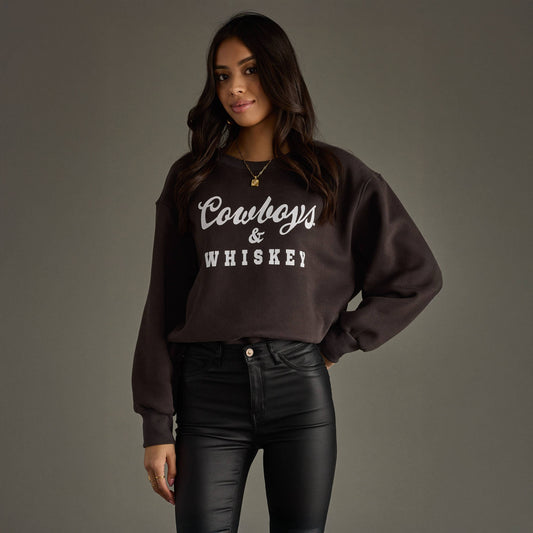 Woman wearing sweatshirt that says Cowboys & Whiskey.