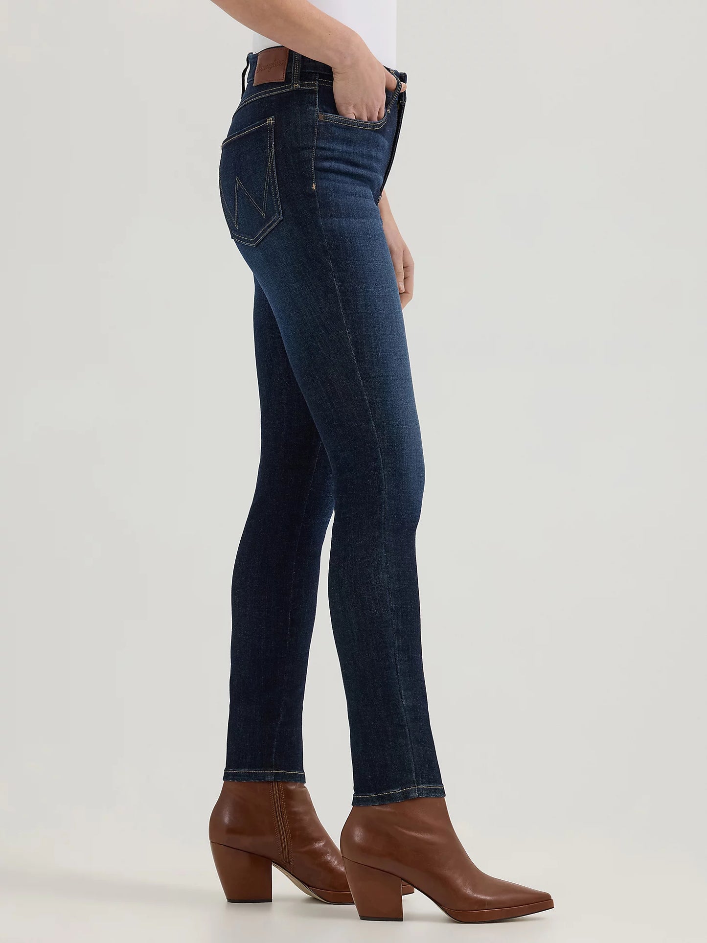 Woman wearing dark blue jeans and brown boots.
