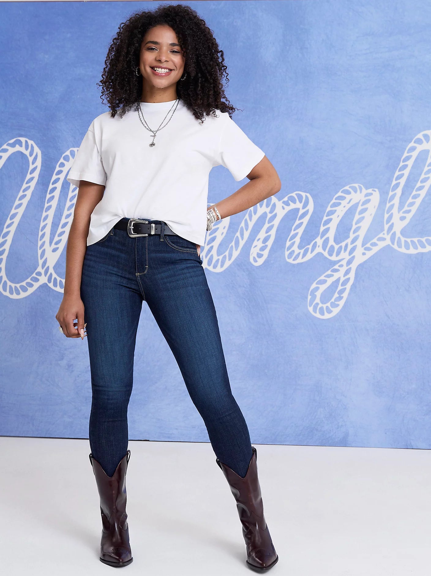 Woman in jeans, t-shirt, and boots.