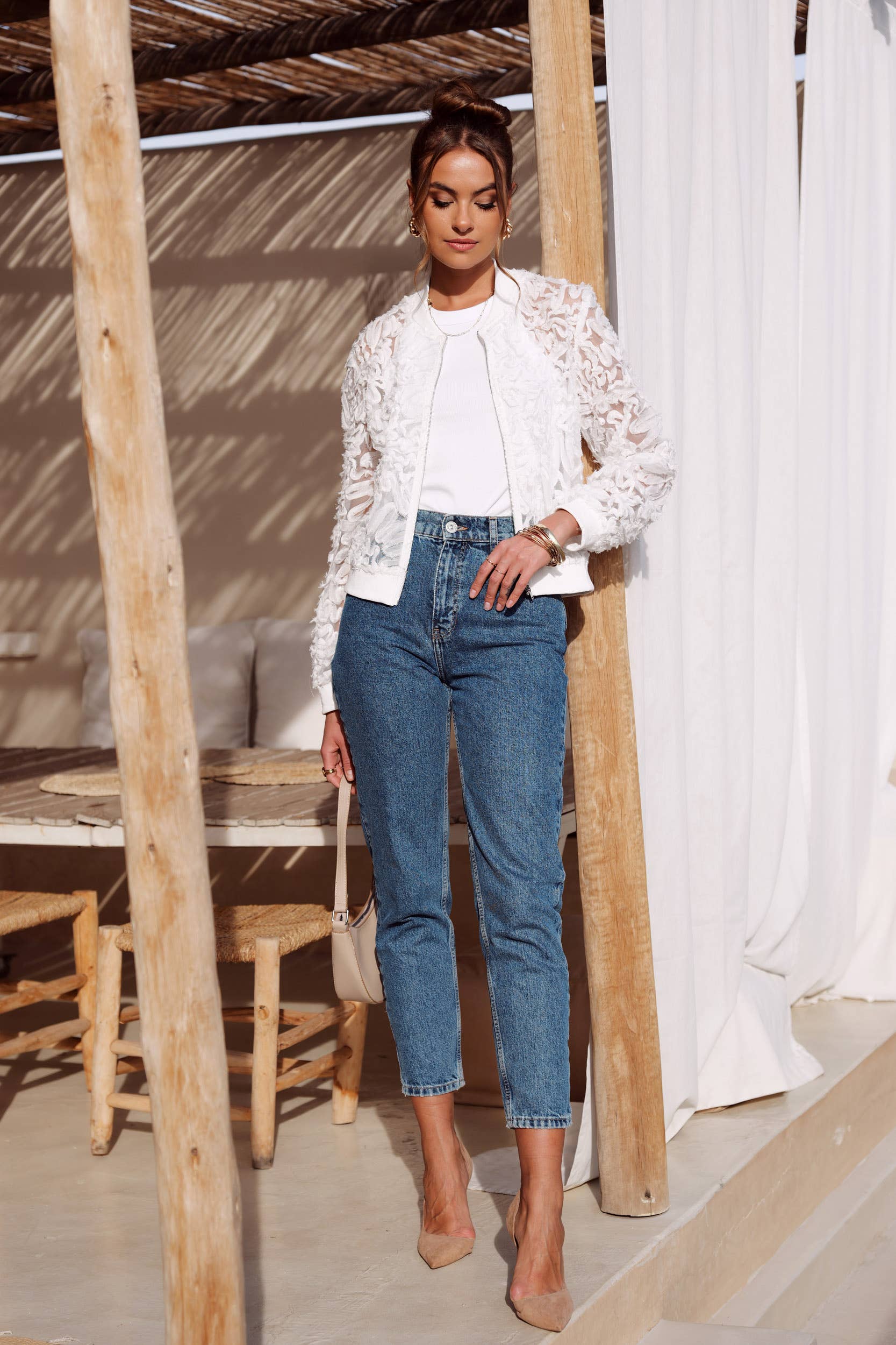 Woman in jeans and white jacket.