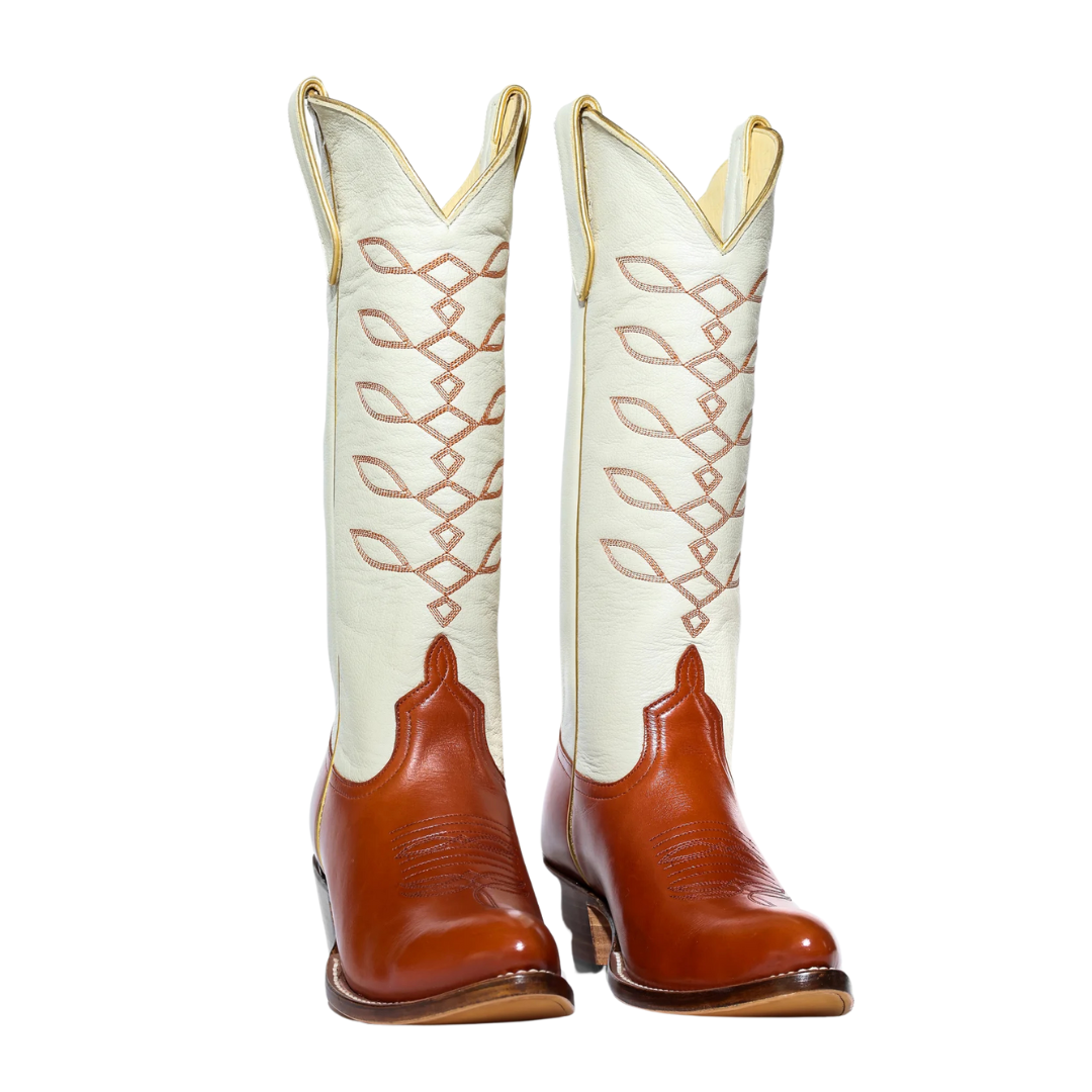 White and brown cowboy boots with decorative stitching