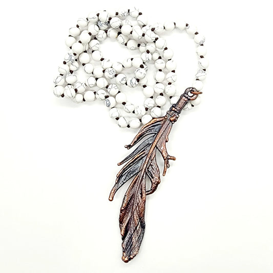 White beaded necklace with feather pendant.