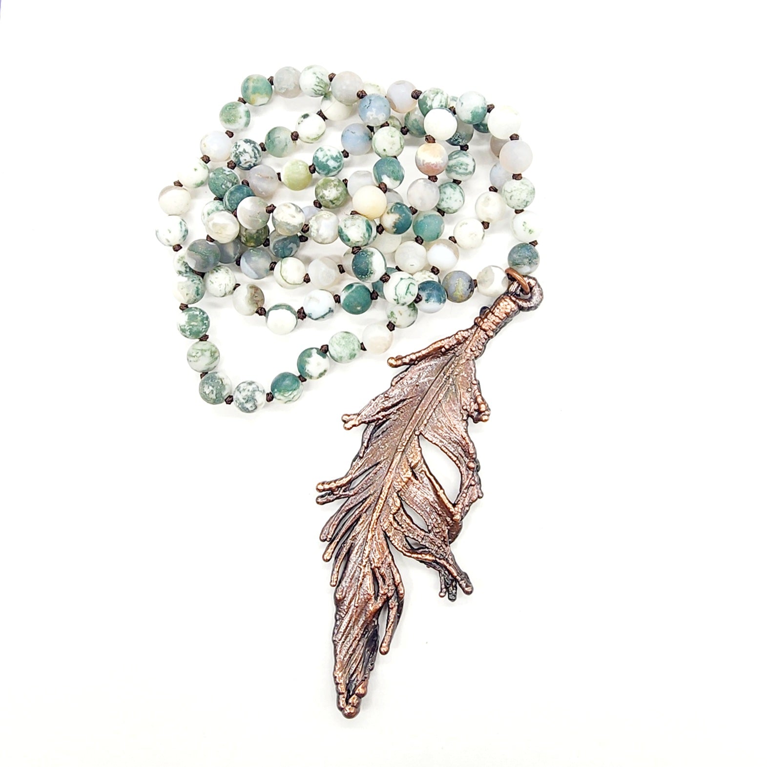 Necklace with green beads and a feather pendant.