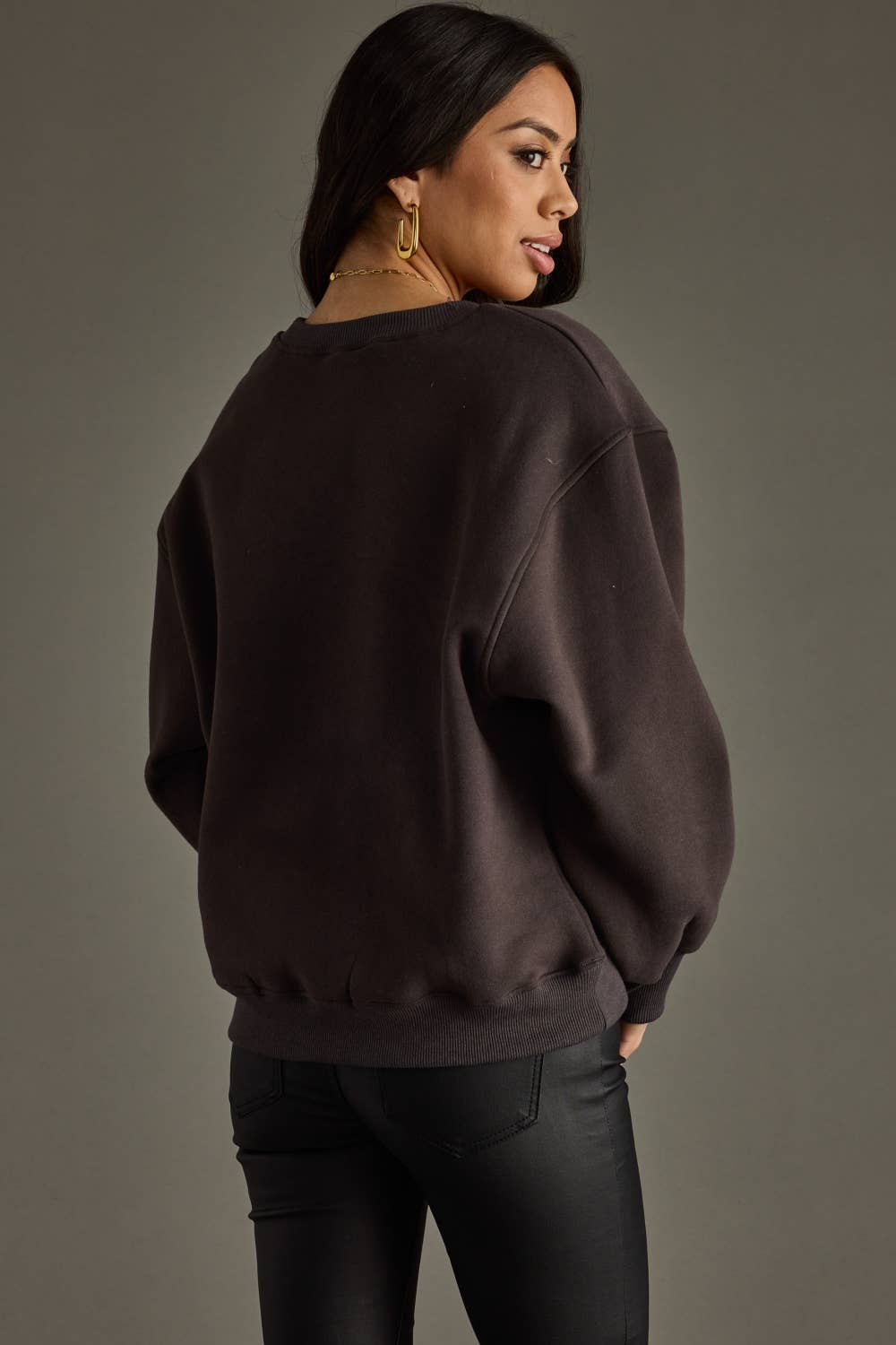 Woman wearing dark sweatshirt and black pants.