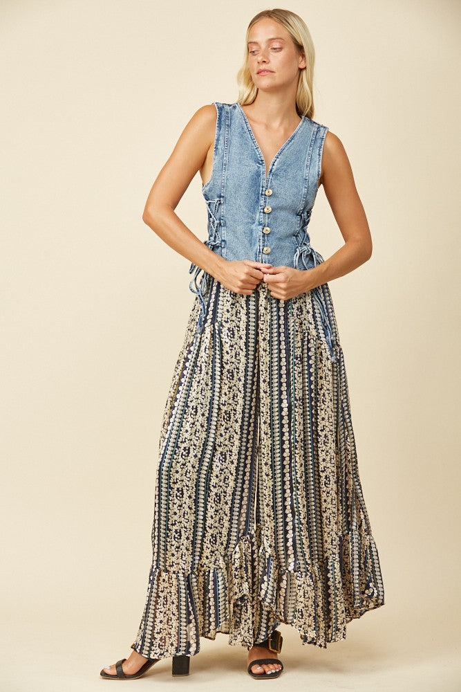 Woman in denim vest and long patterned skirt.