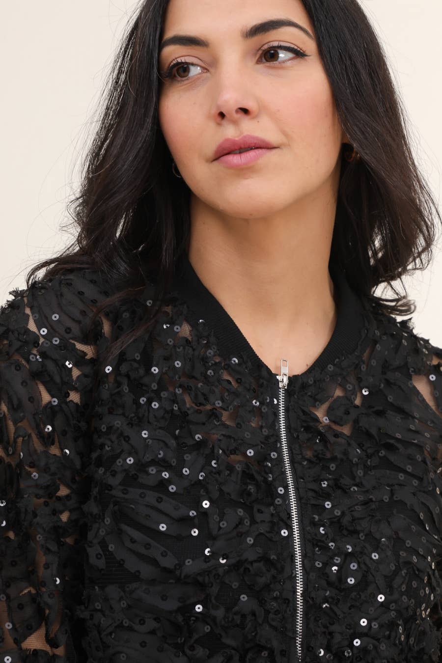 Woman in black sequined bomber jacket.