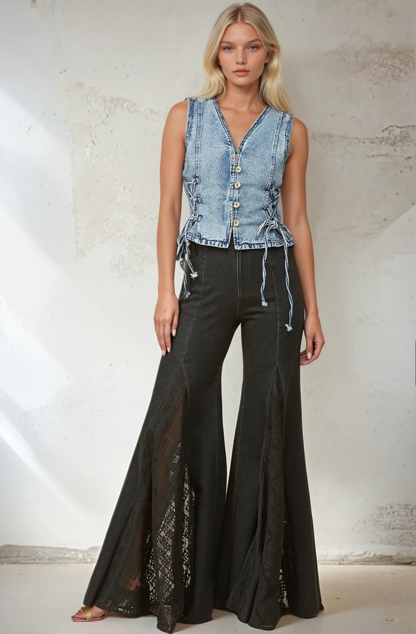 Woman wearing denim vest and black flared pants.