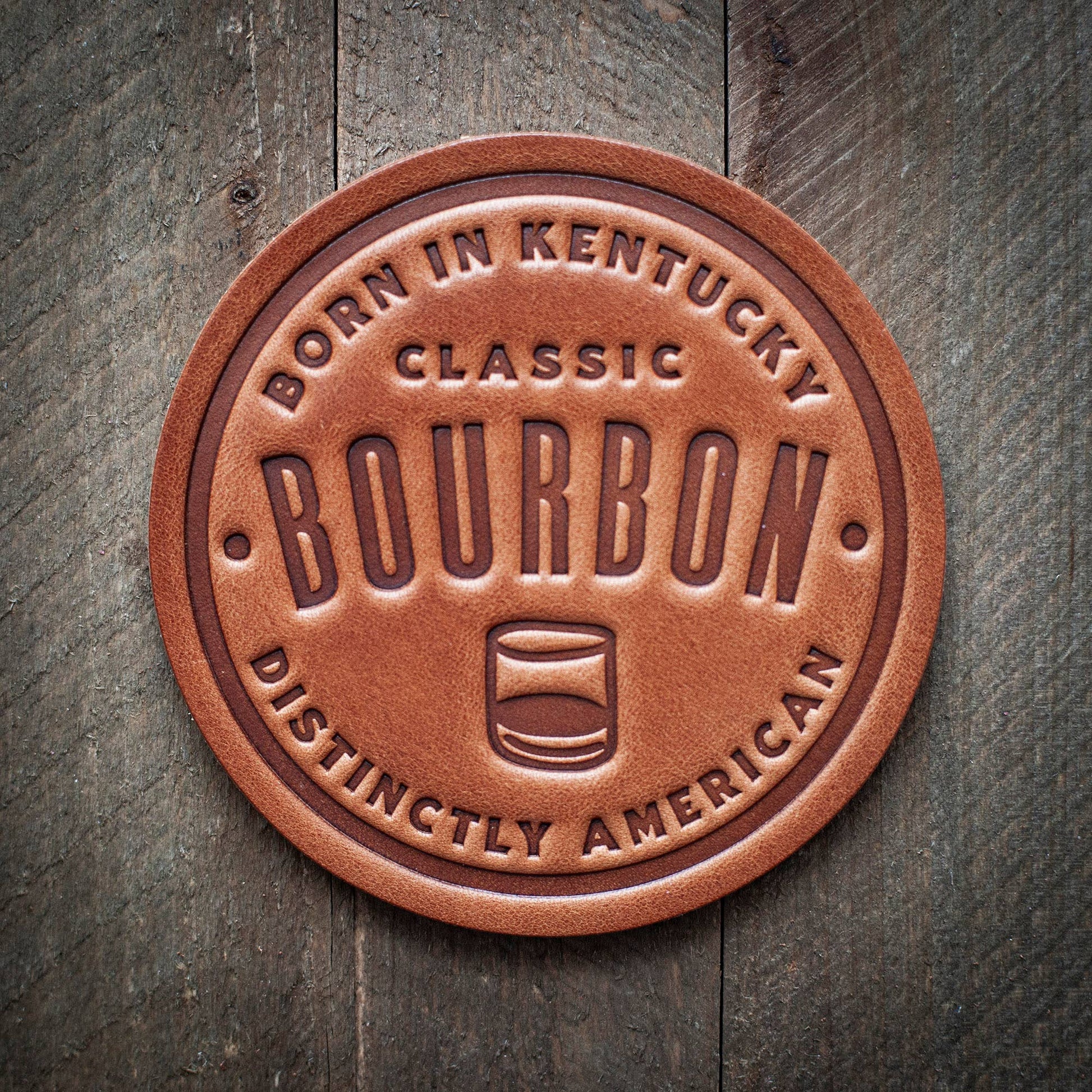 Leather bourbon coaster on wood