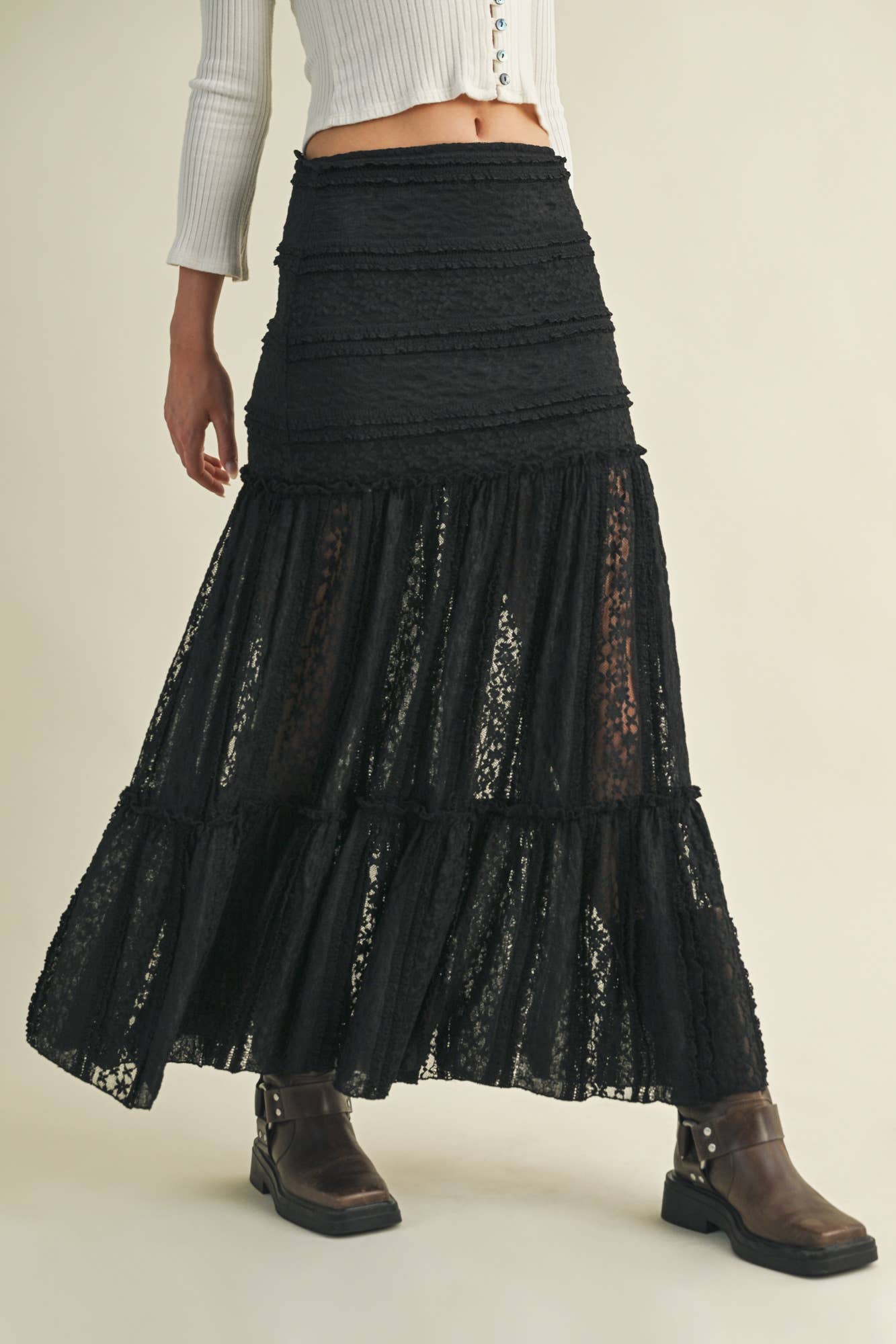 Woman wearing black lace skirt and boots.