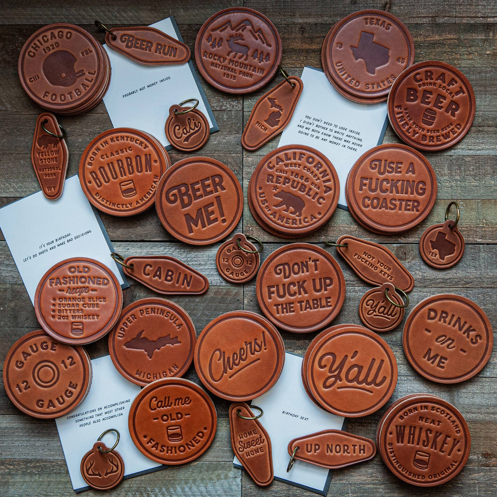 Leather coasters and keychains with text.