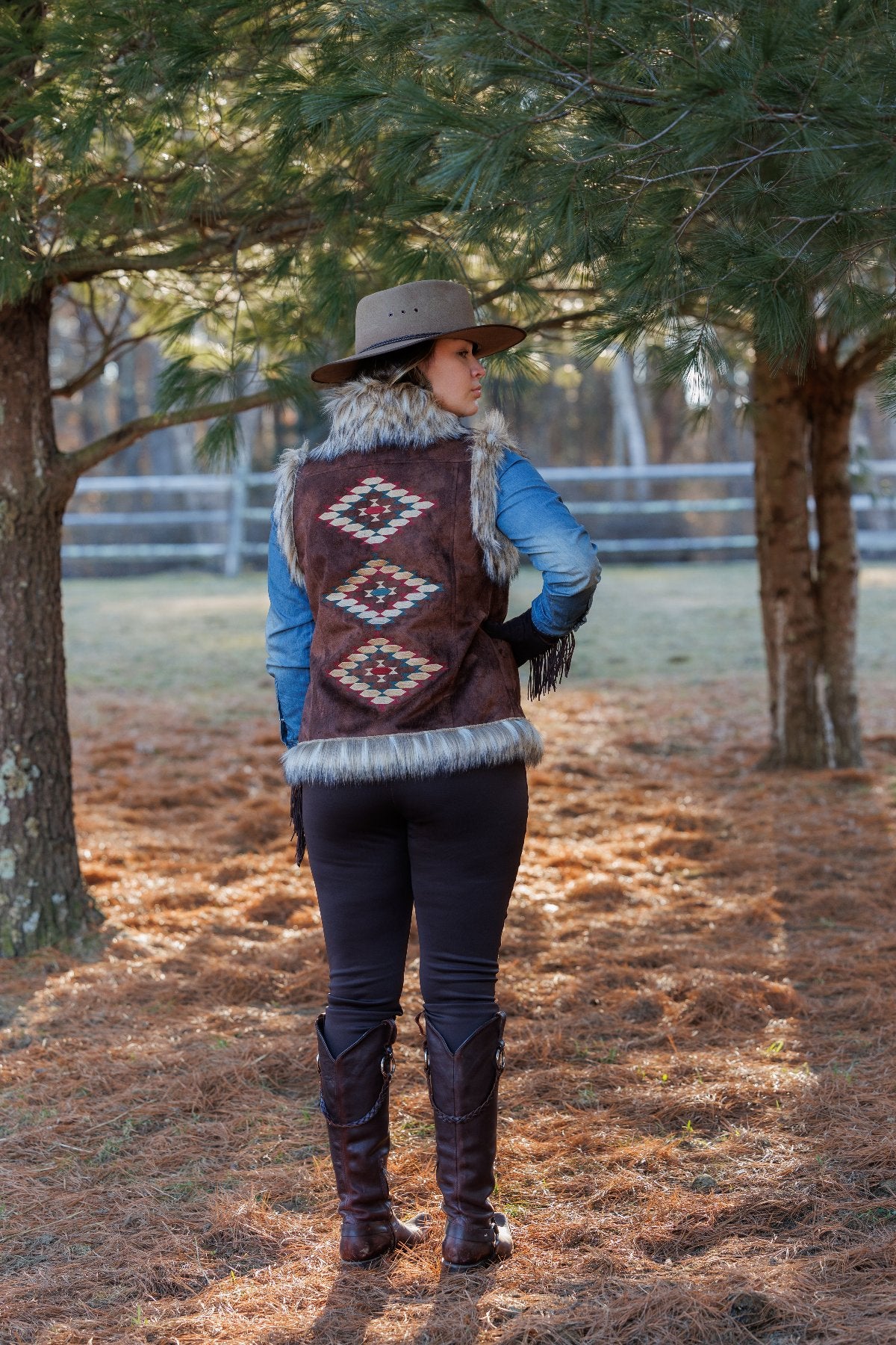 Woman wearing brown vest & cowboy hat