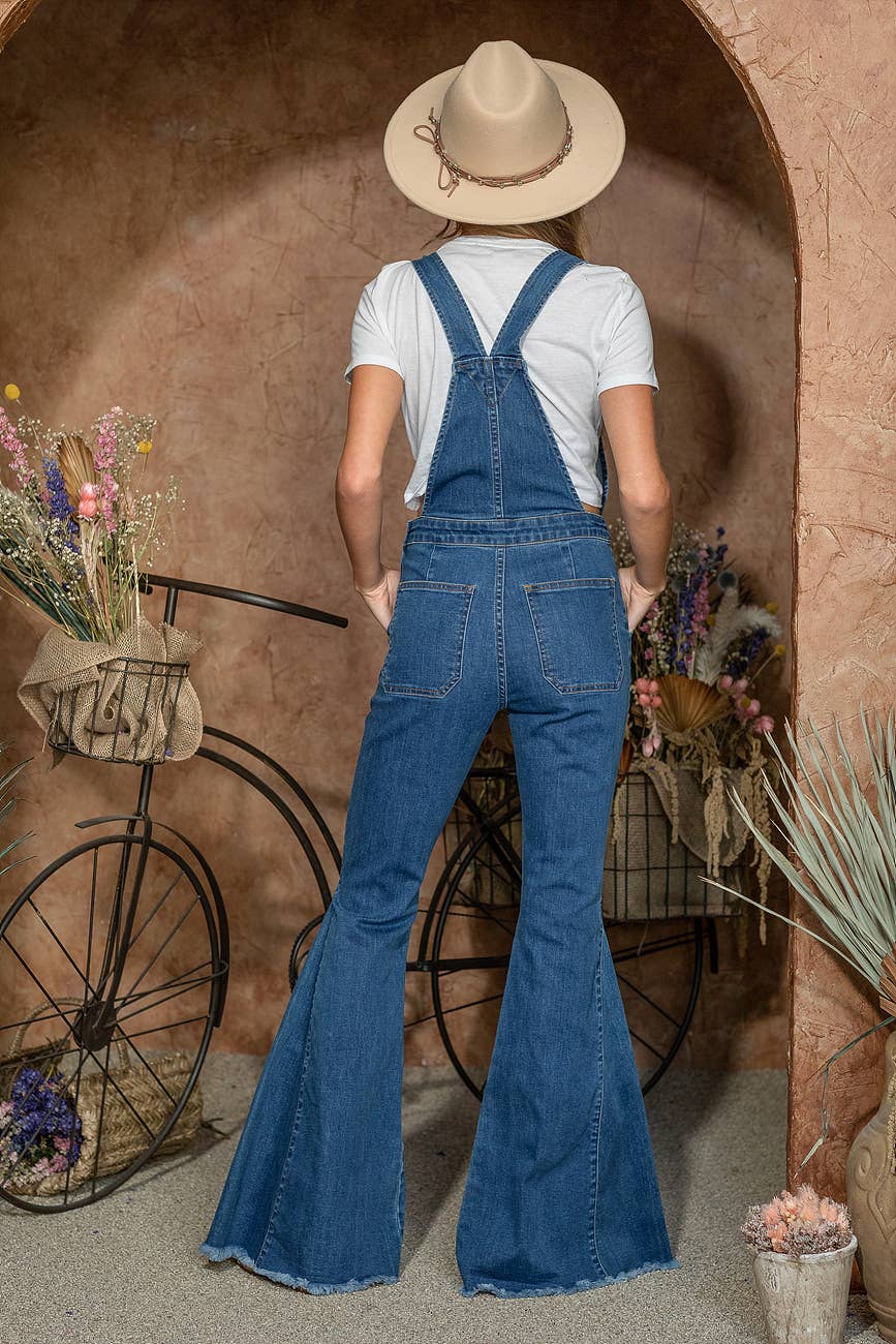Woman in denim overalls and hat.