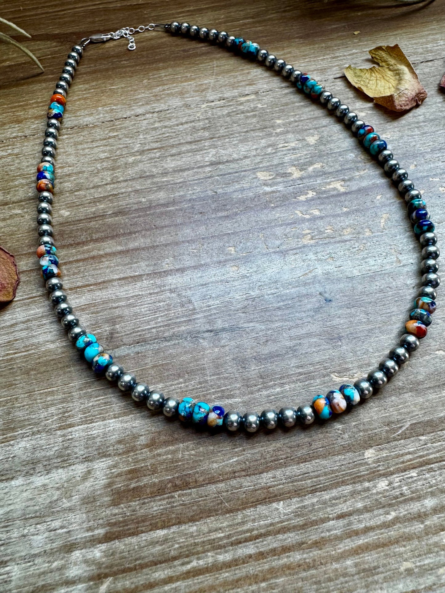 Turquoise & silver bead necklace (43D76281-4E19) on wood surface