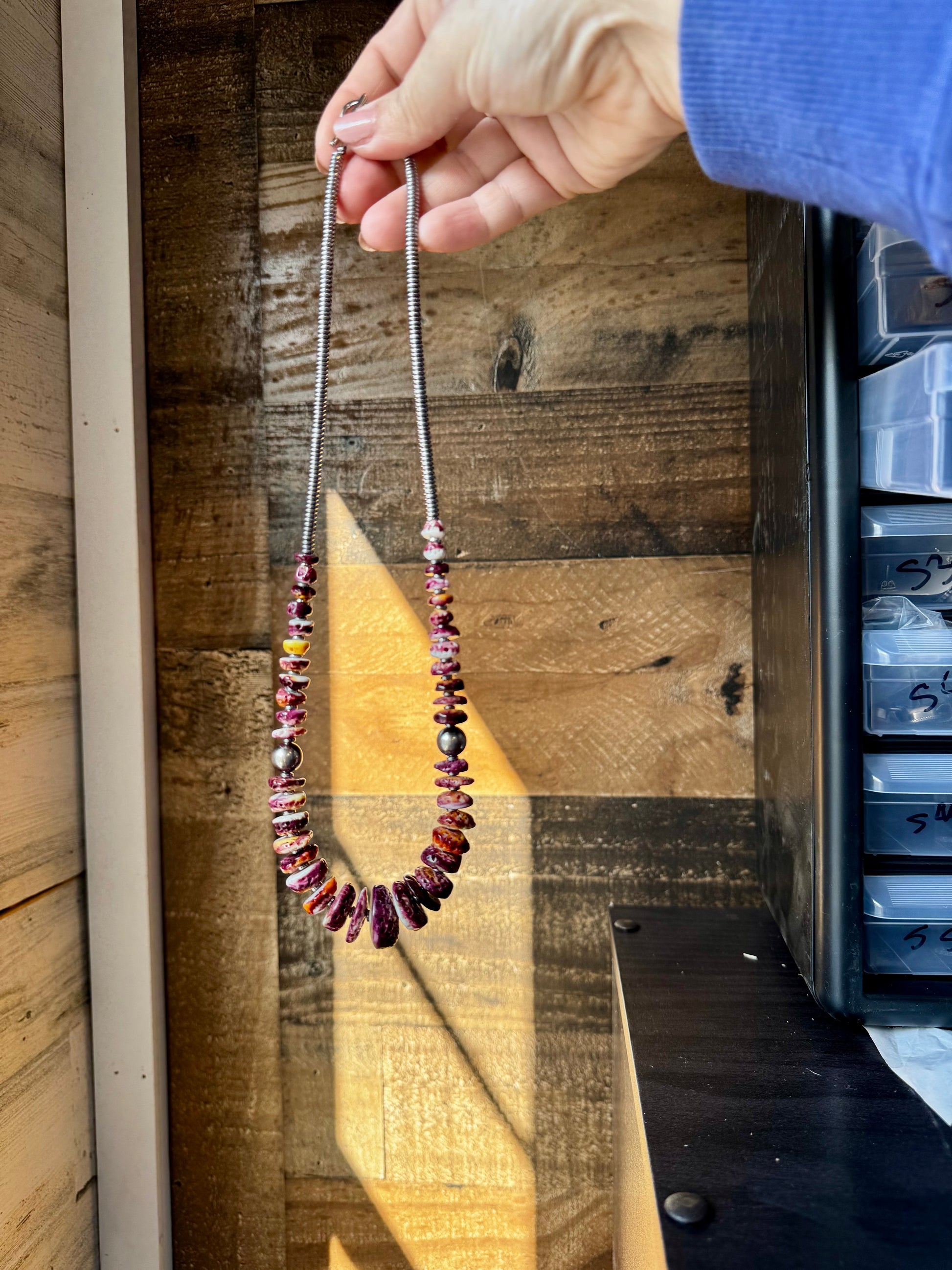 Hand holding a beaded necklace, 482E8851-ED8C-463F-A7A3-58B493F2B793