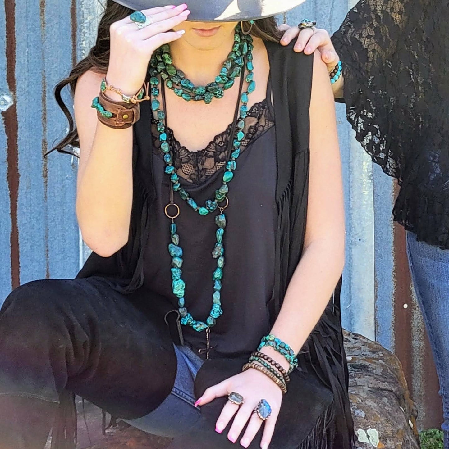 Woman in black outfit wearing turquoise jewelry.