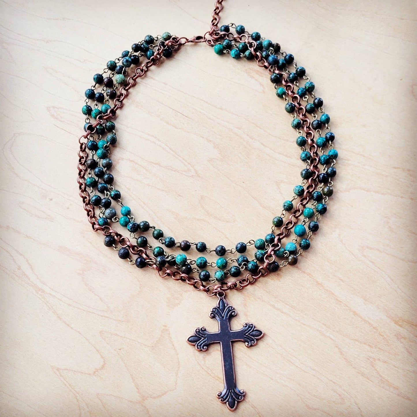 Necklace with cross pendant and turquoise beads.