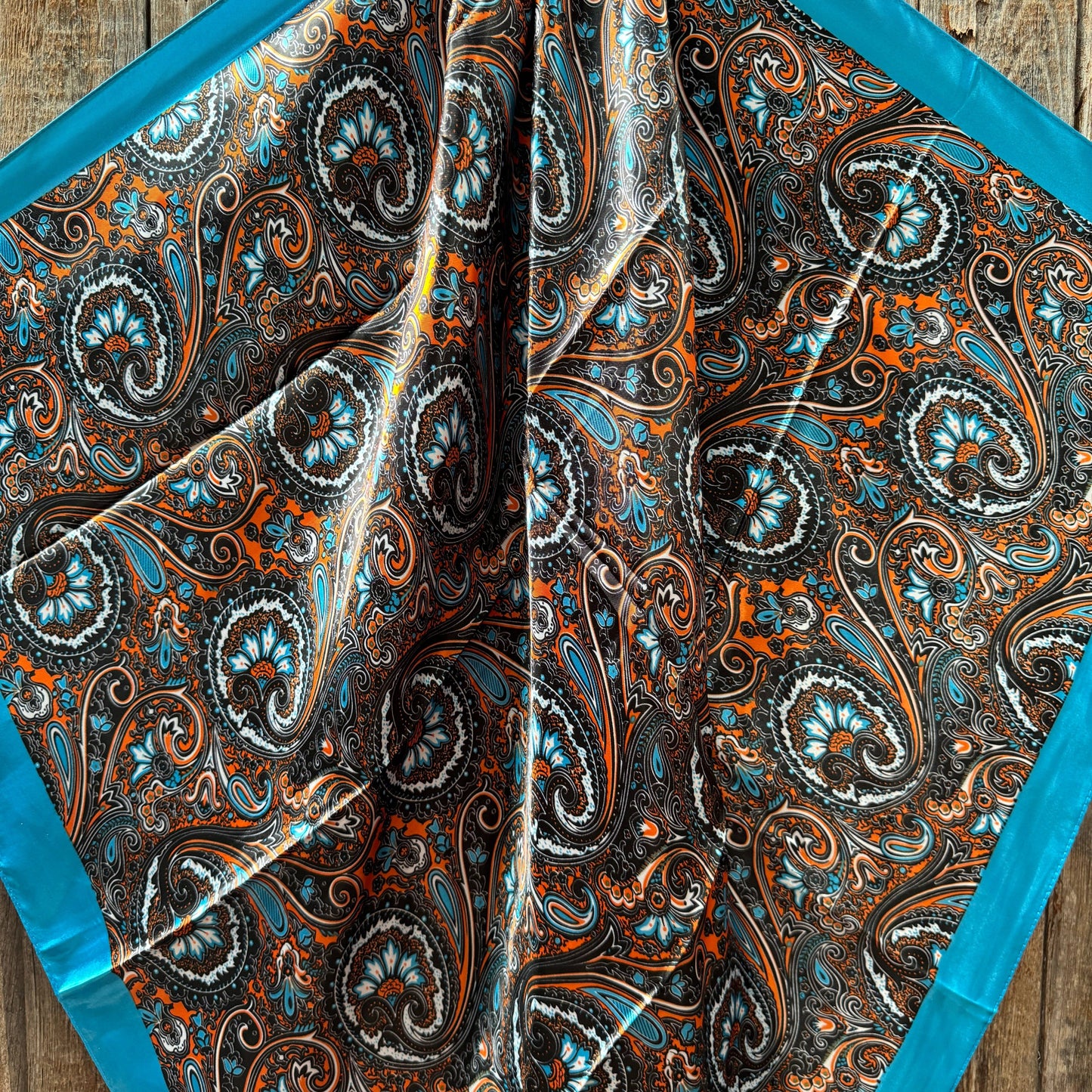 Paisley patterned scarf with blue border.