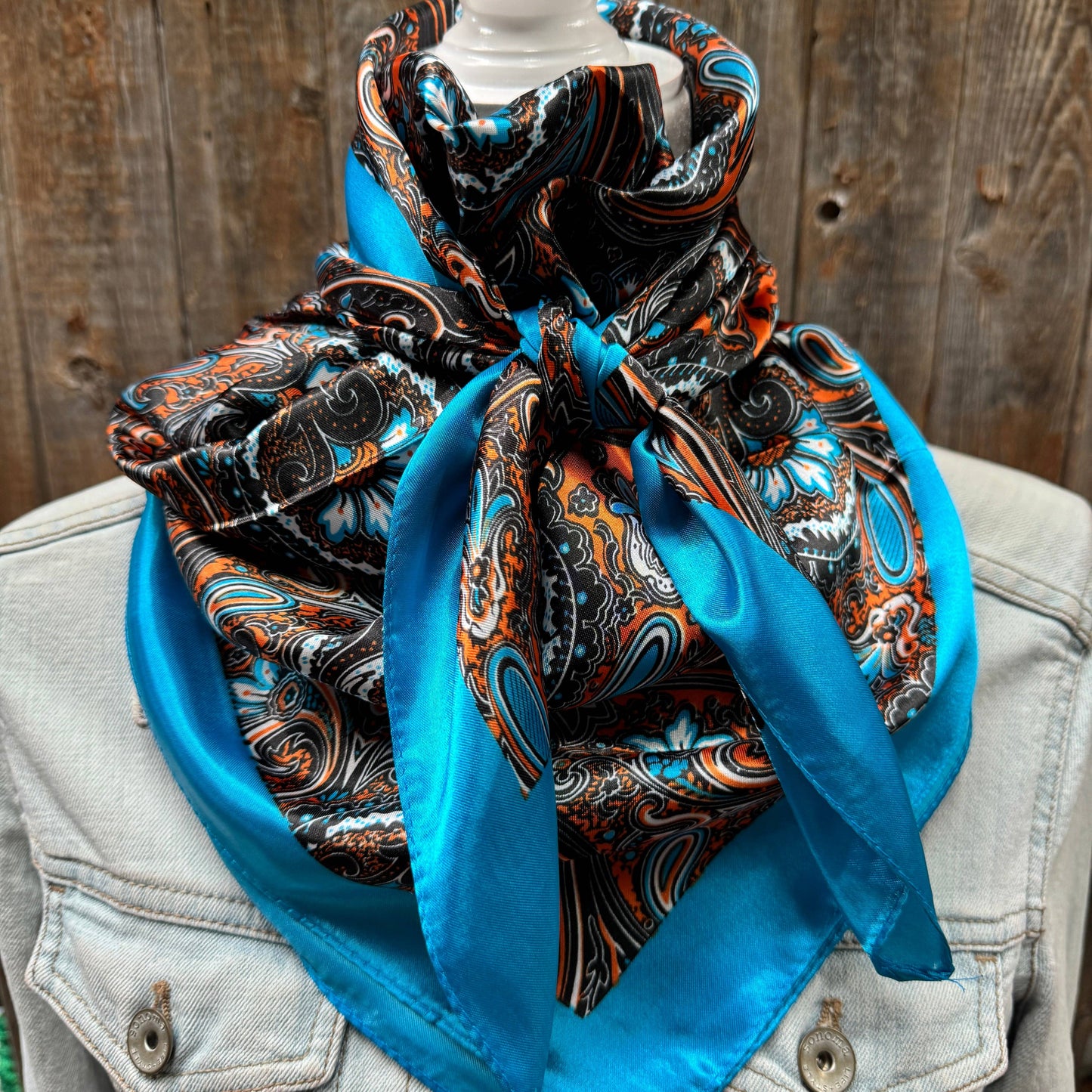 Blue and patterned paisley scarf around a neck.