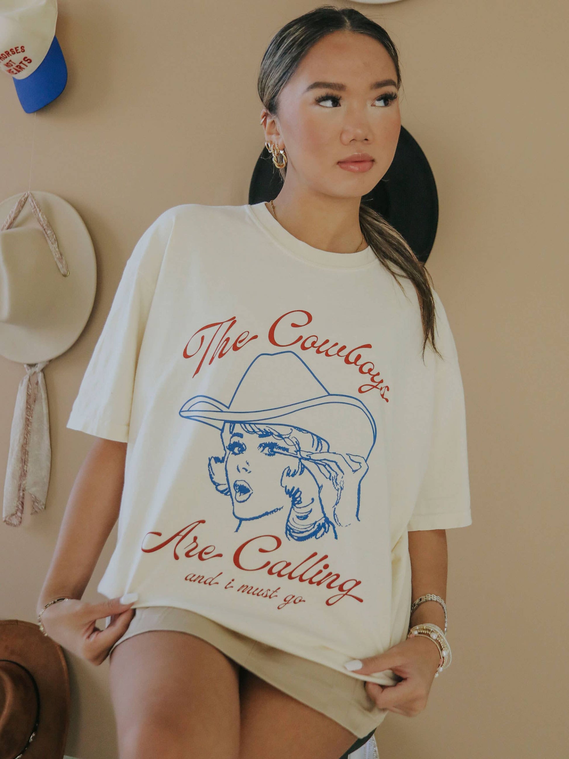 Woman wearing cream-colored t-shirt with cowboy graphic.