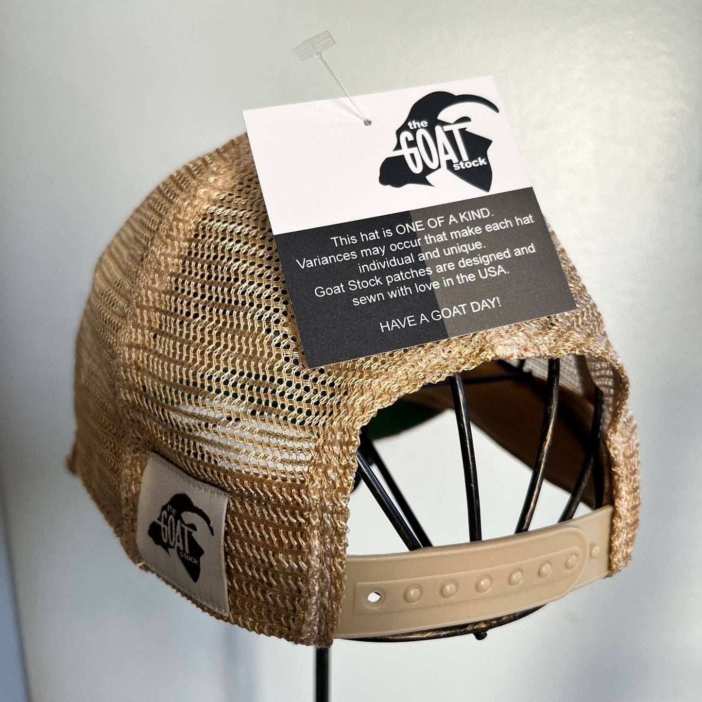 Tan mesh trucker hat with tag.
