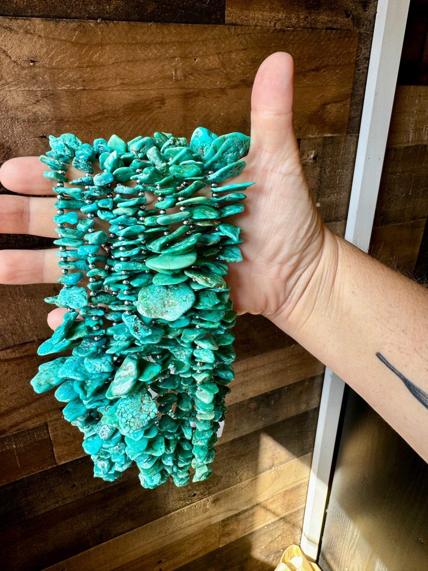 Turquoise stone bracelet held in hand (5F9B7F09-7632-4DB4)