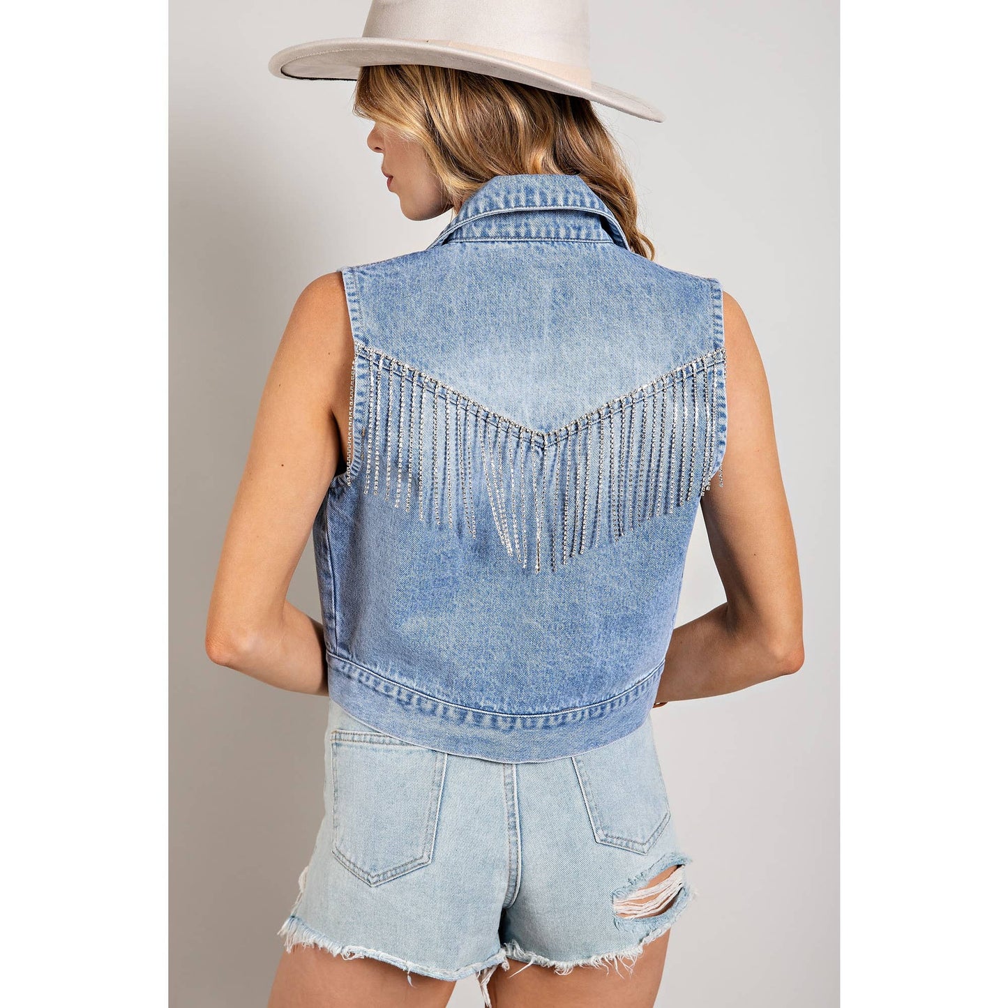 Woman wearing denim vest with fringe.