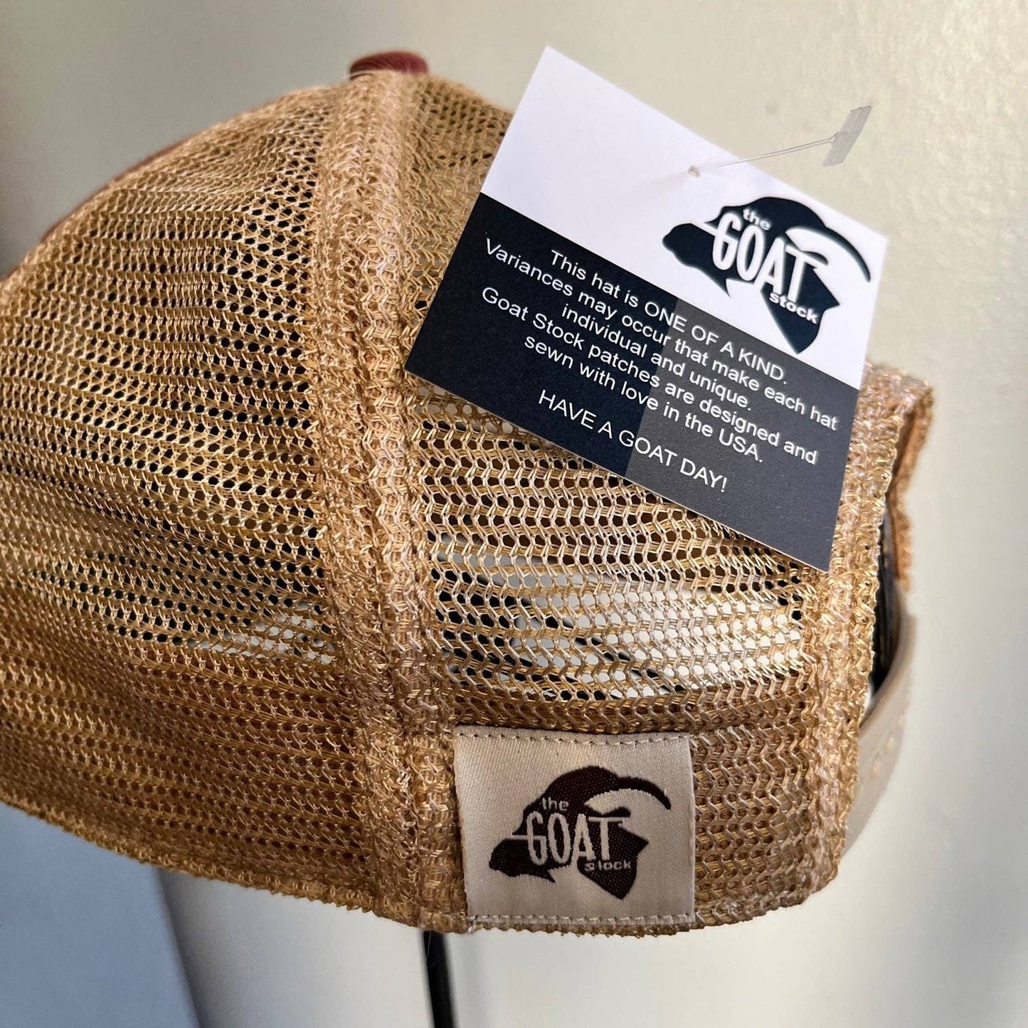 Brown mesh-backed hat with The Goat Stock tag.
