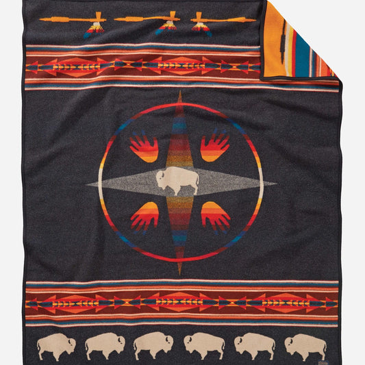 Blanket with bison, compass, and geometric patterns.