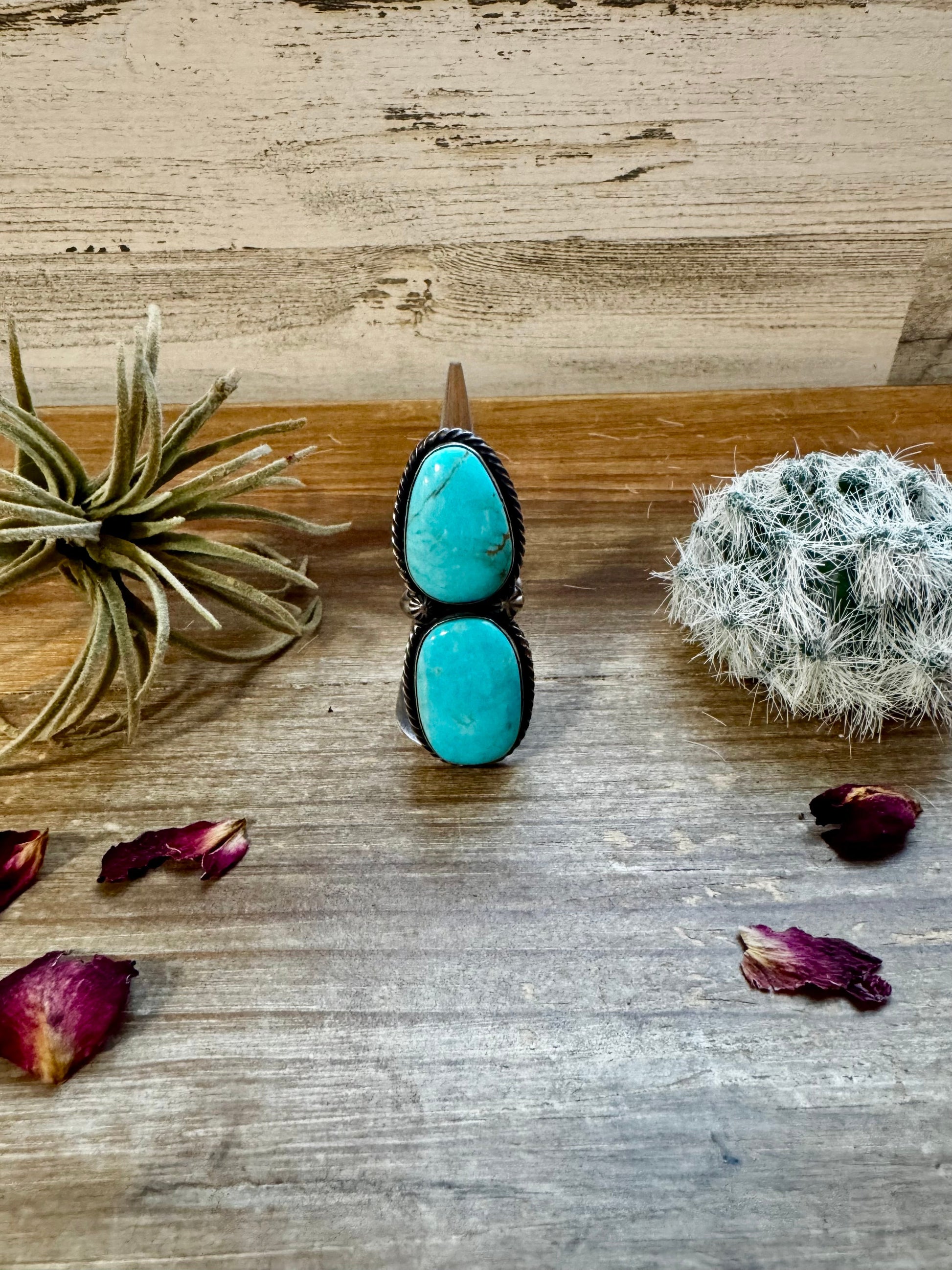 Turquoise ring (7479C83F) on wood, with air plant and petals.