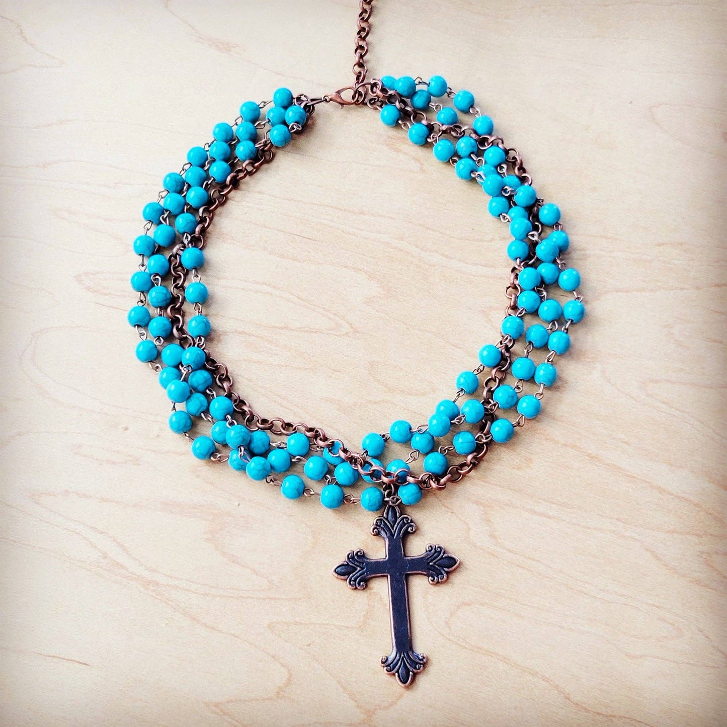 Turquoise beaded necklace with a cross pendant.