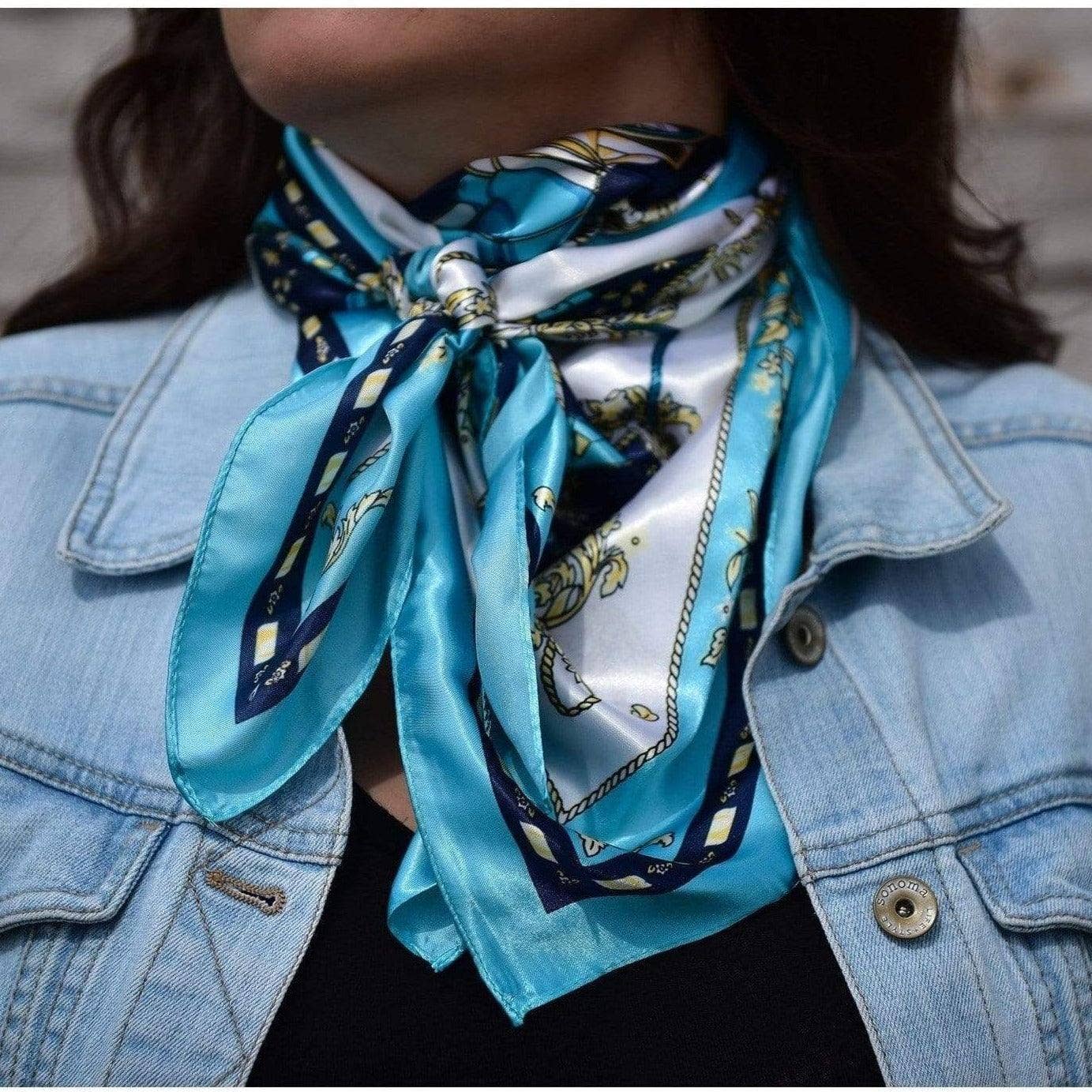 Woman wearing a blue scarf and denim jacket.