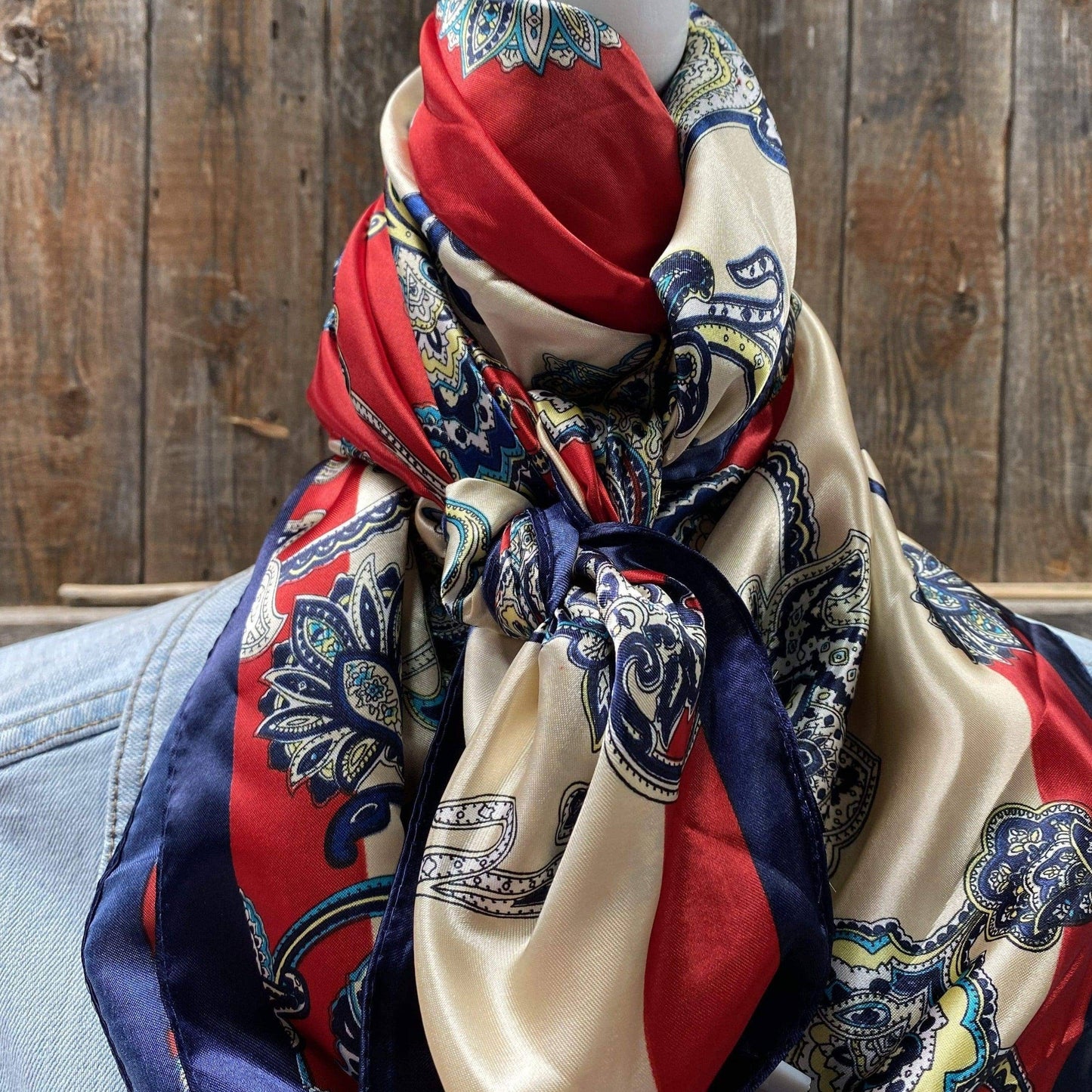 Silk scarf with paisley print and red and blue accents.