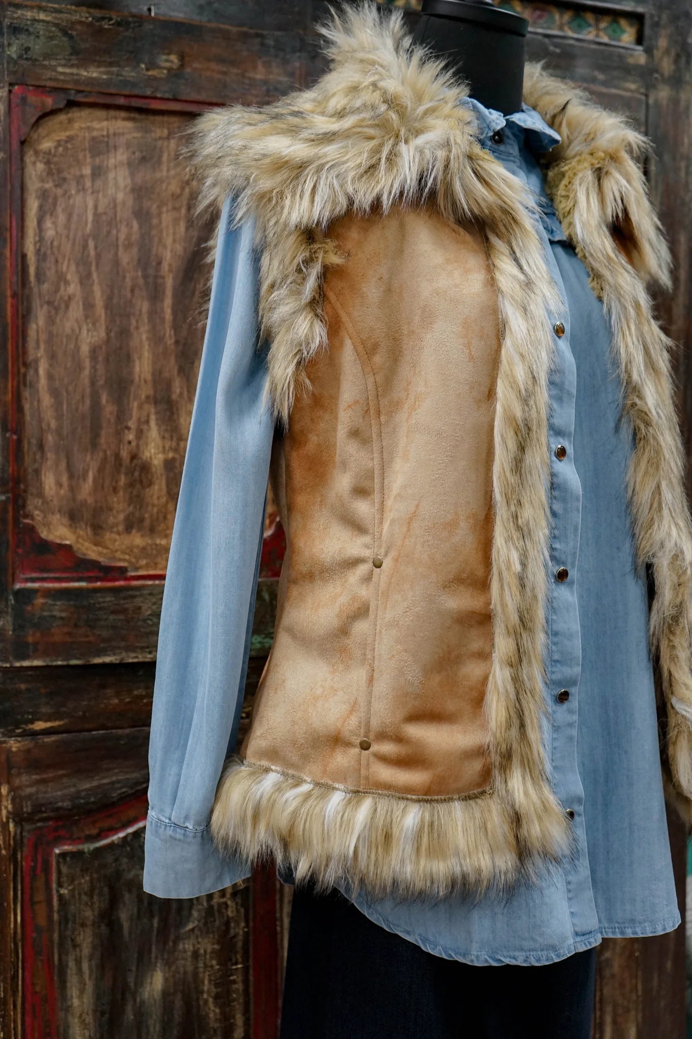 Faux fur vest over denim shirt