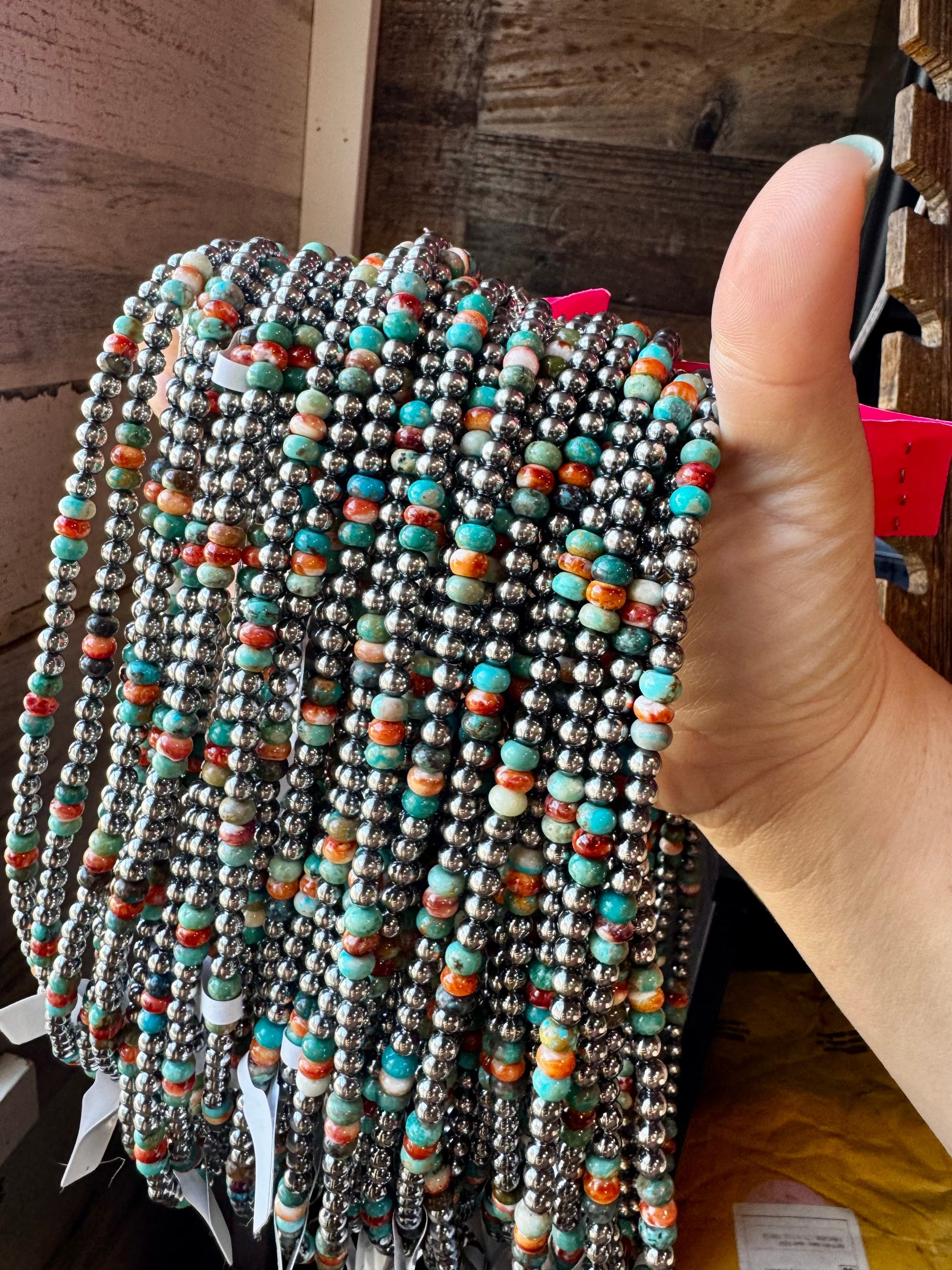 Hand holding beaded necklaces, A48298B4-0A00-48F3-A829-2FD54BD40A5B