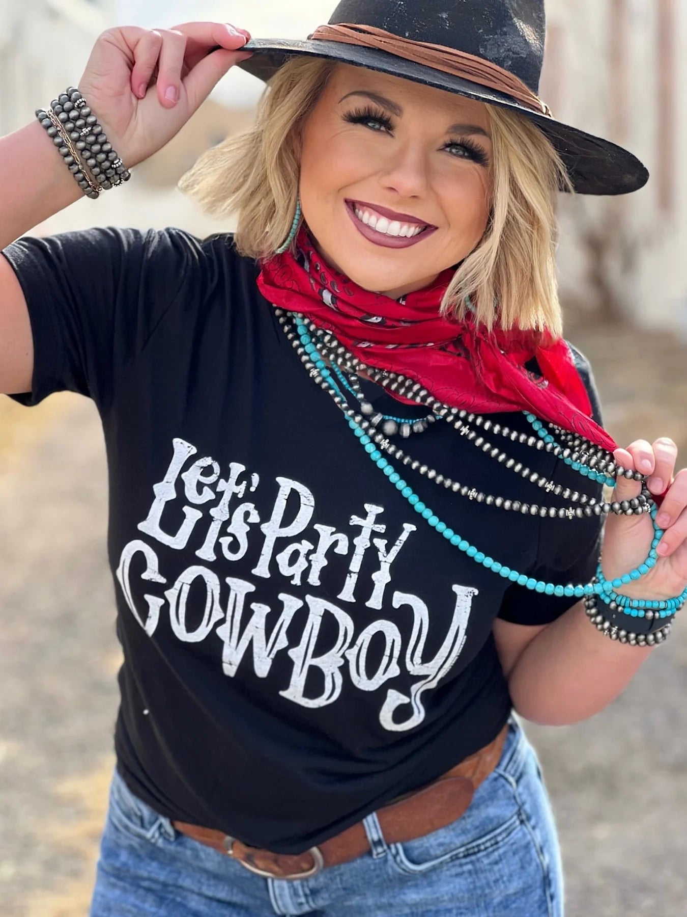 Cowgirl in Let's Party Cowboy shirt, hat, and turquoise jewelry.