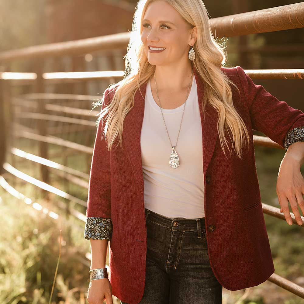 Woman in red blazer by fence