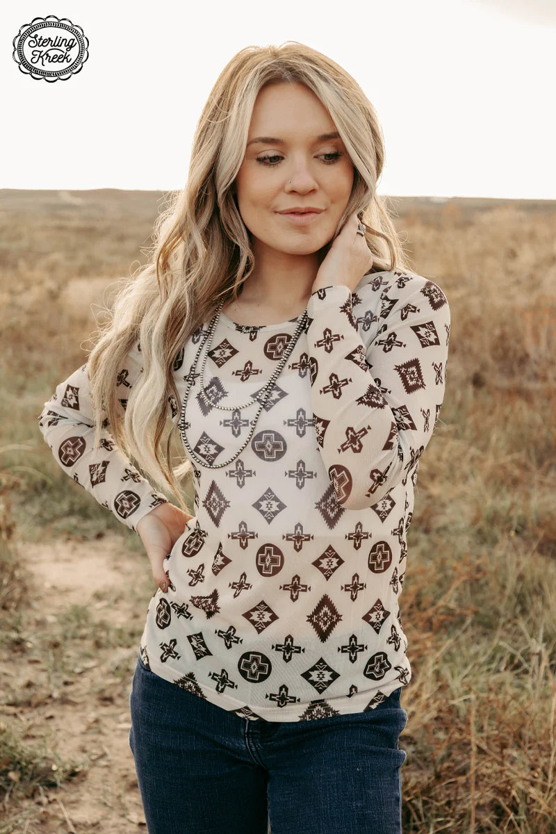 Woman wearing brown and cream patterned top