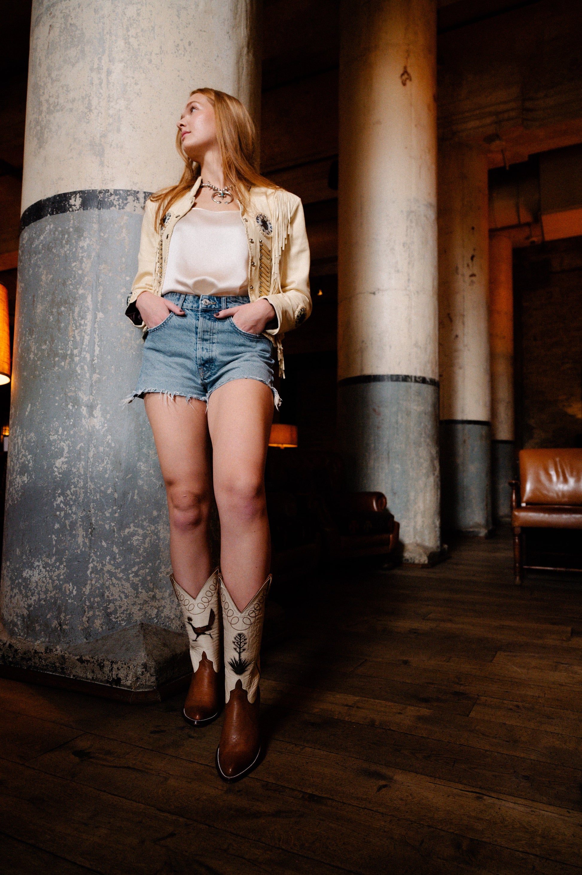 Woman in shorts and cowboy boots leaning against a column (DSC_0321)