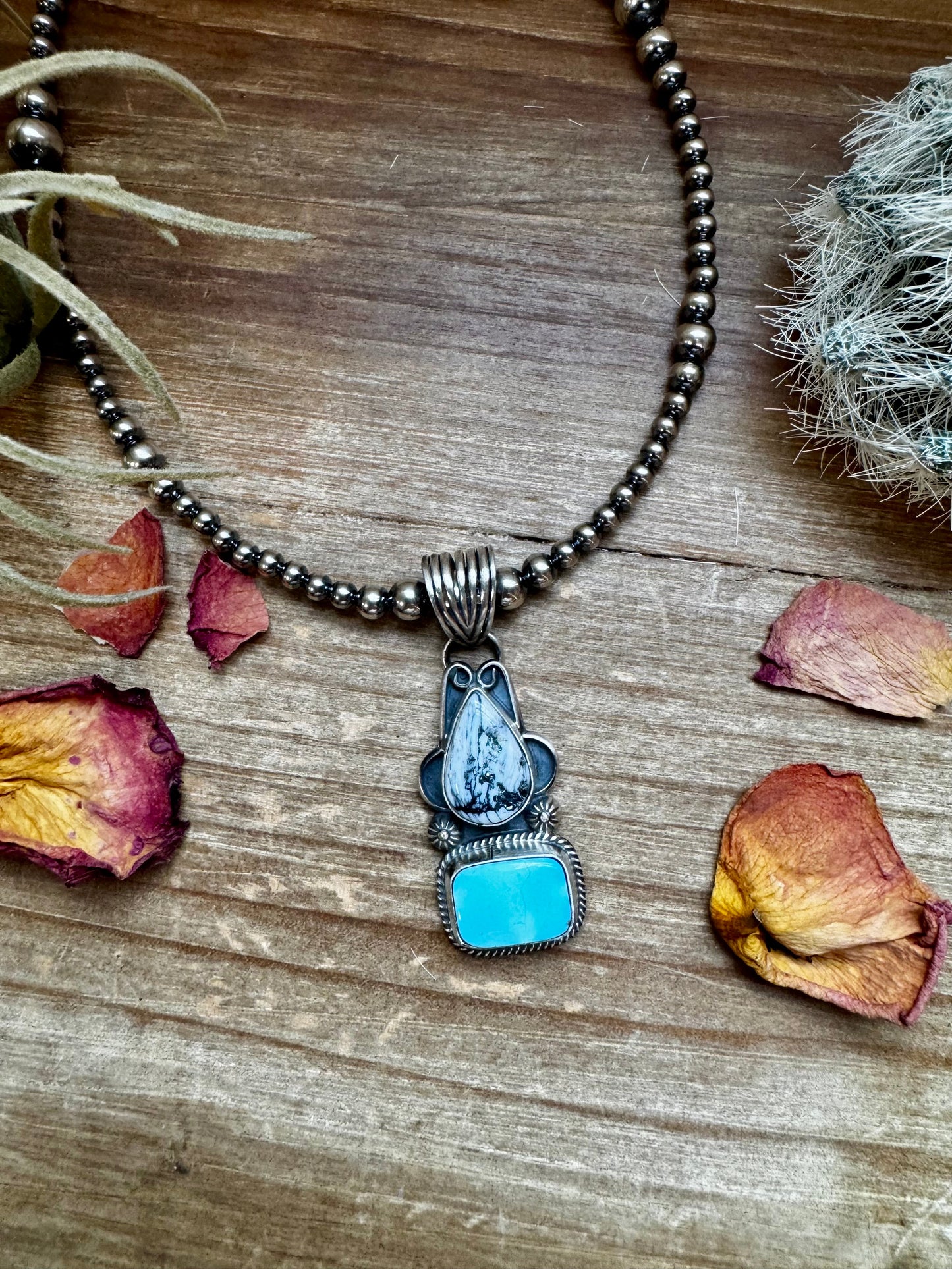 Turquoise pendant necklace on wood surface.