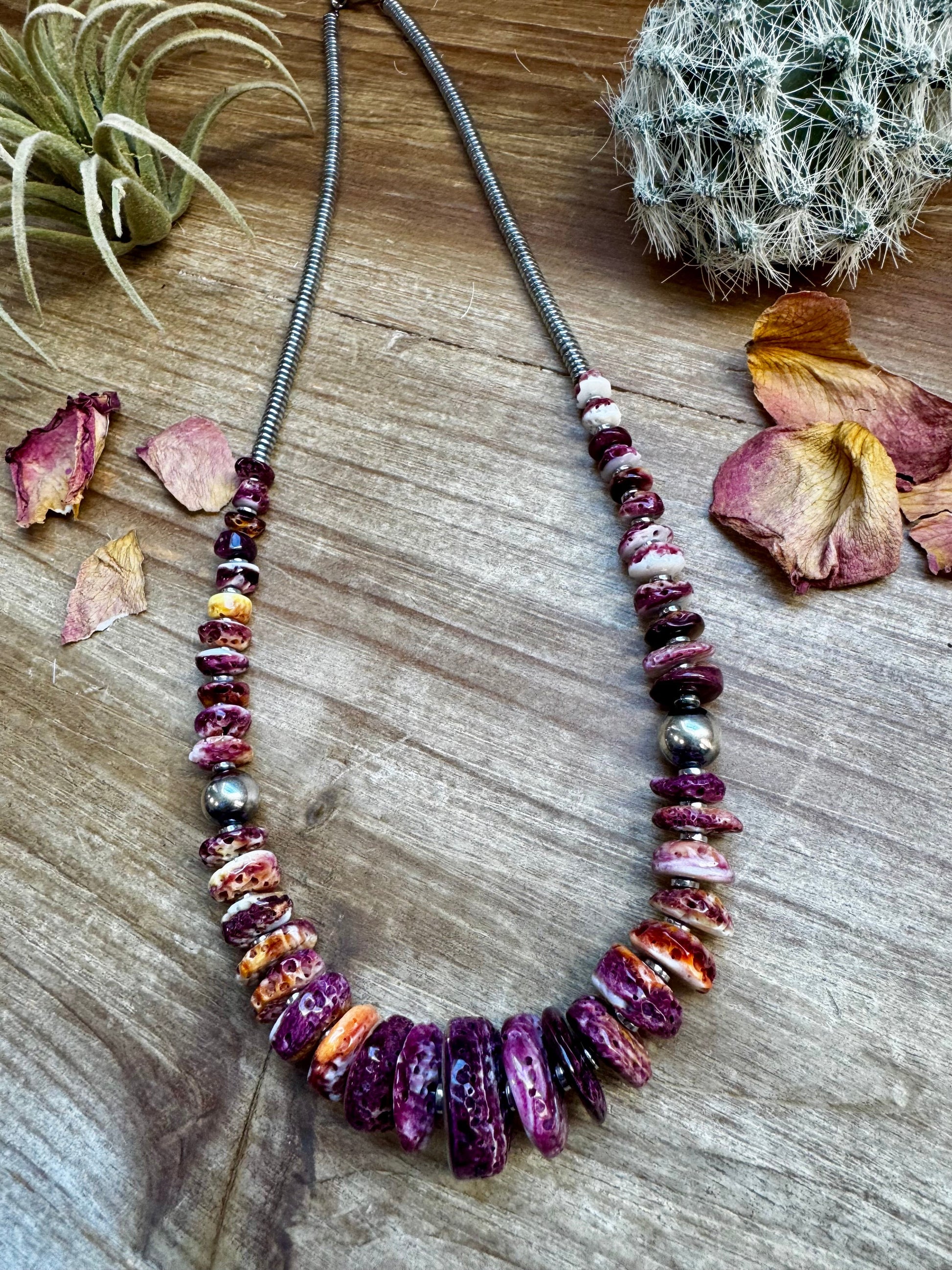 Purple beaded necklace on wood