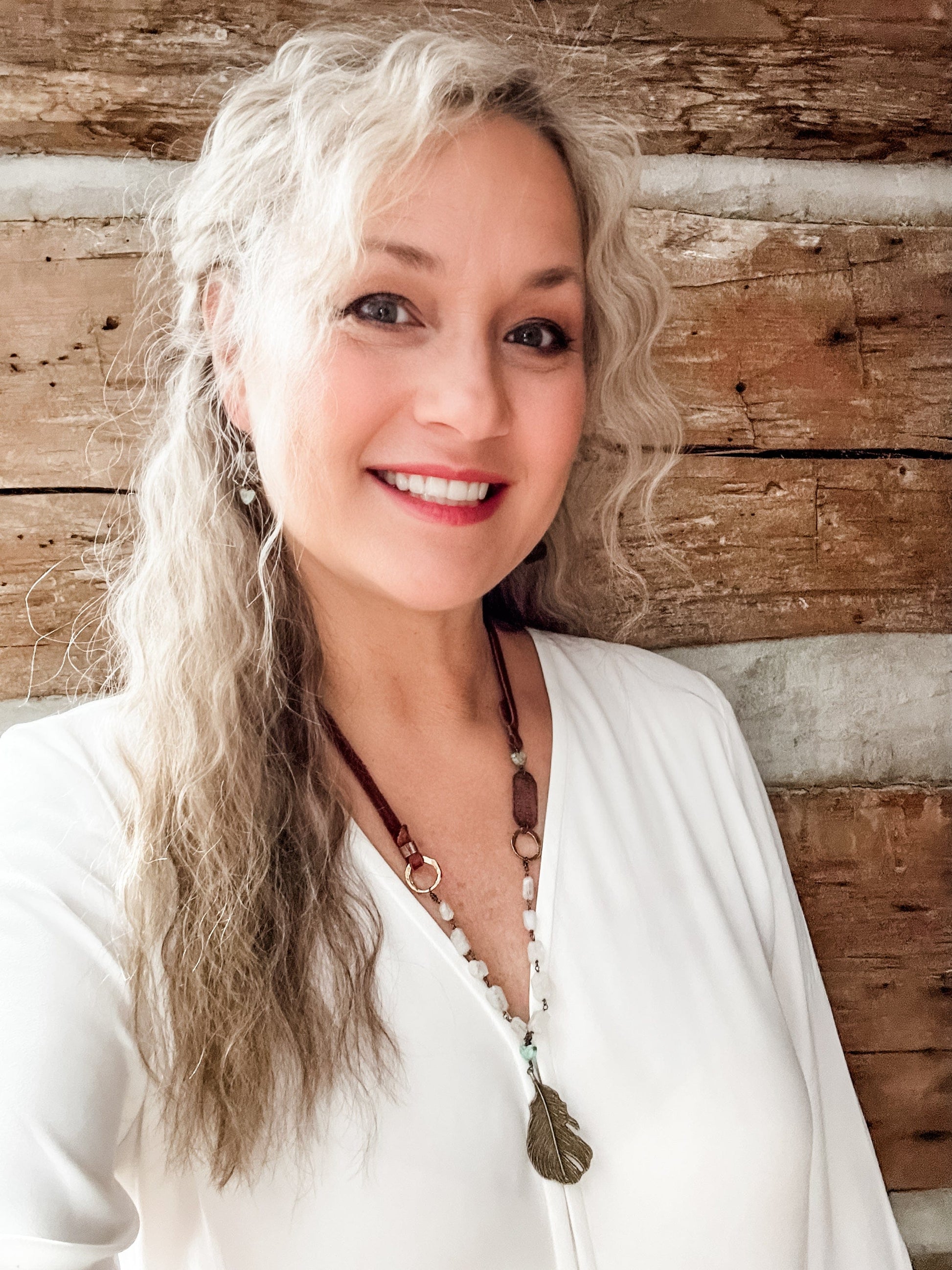 Smiling woman with long gray hair, edited via Facetune
