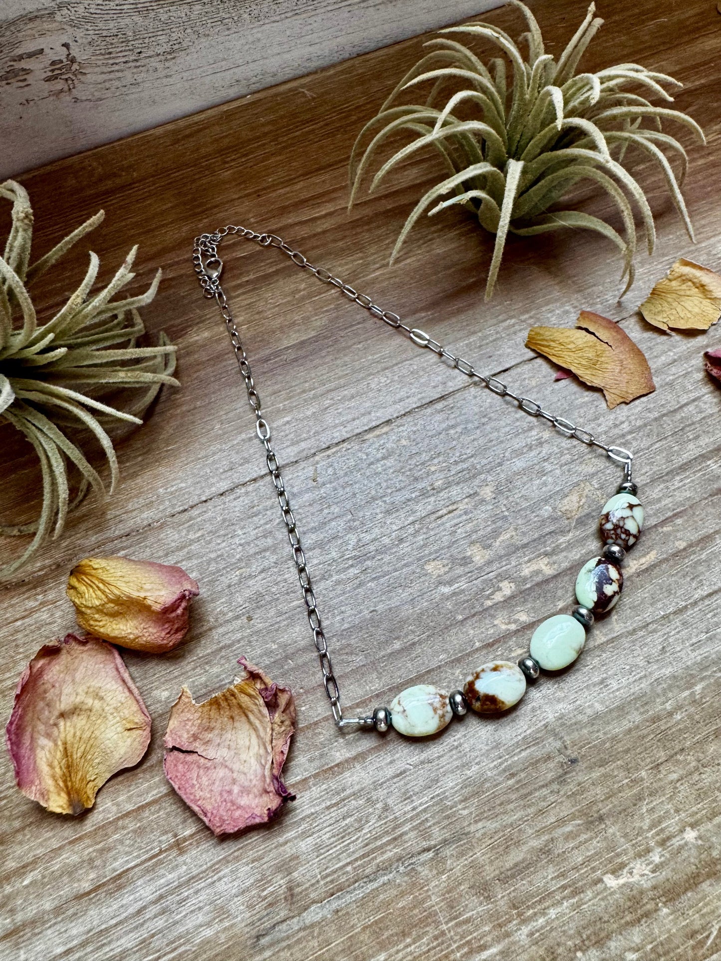 Necklace with stone beads on wood table