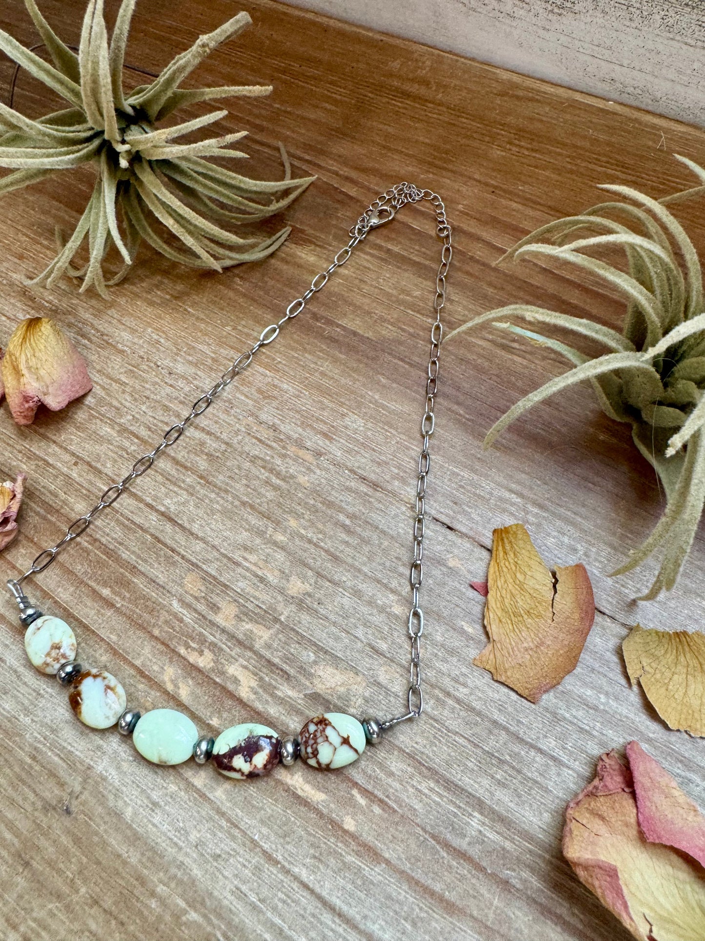 Necklace with beads on wood surface