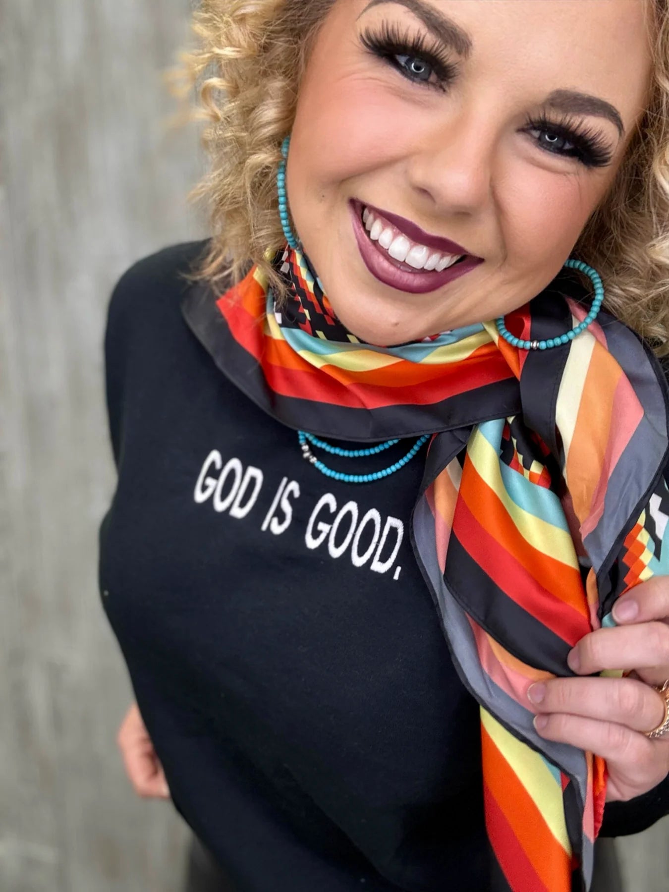Woman smiling, God is Good shirt, colorful scarf