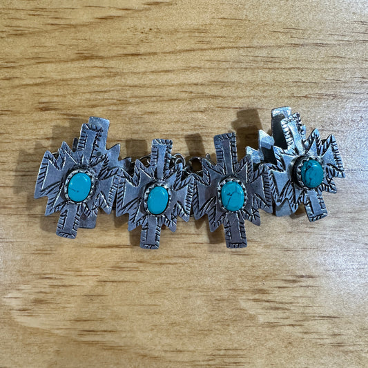 Silver cross-shaped earrings with turquoise stones.