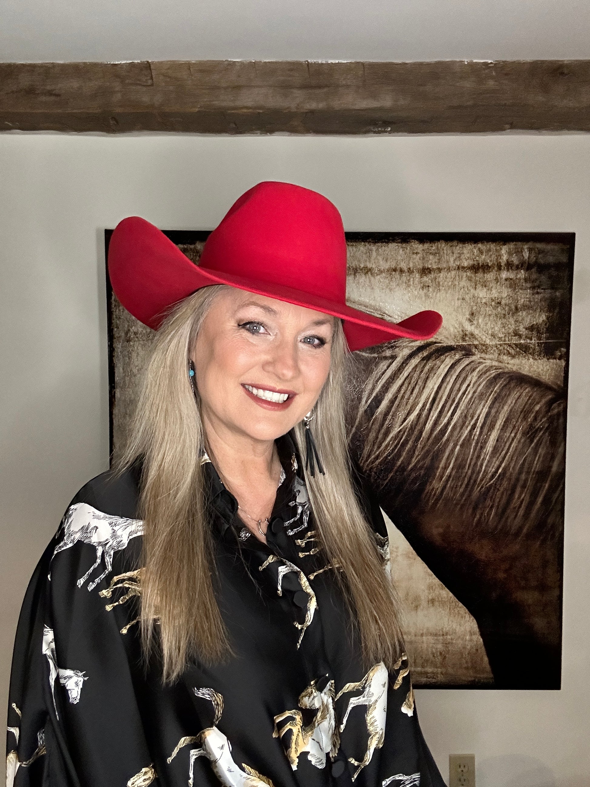 Woman in red cowboy hat and patterned shirt.