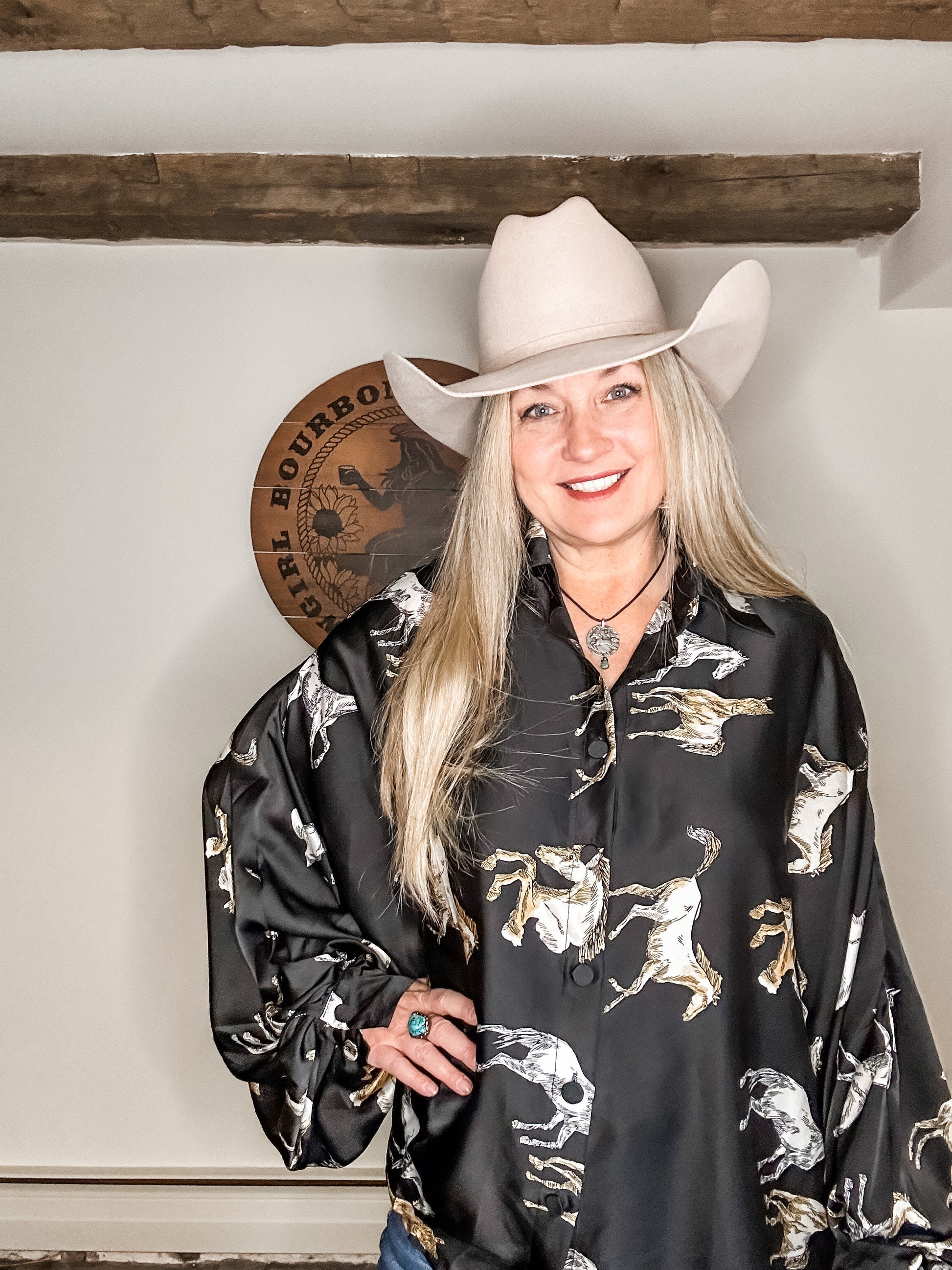 Woman wearing a cowboy hat and patterned shirt.