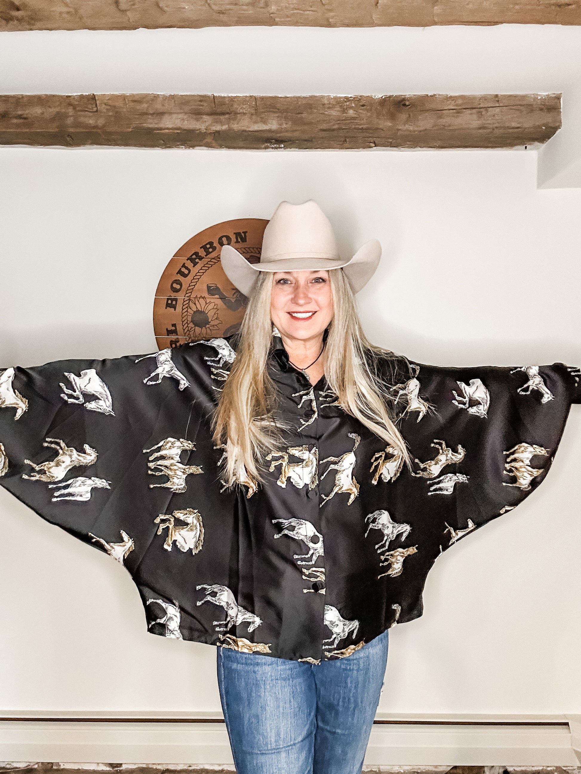 Woman in cowboy hat and horse-print shirt.